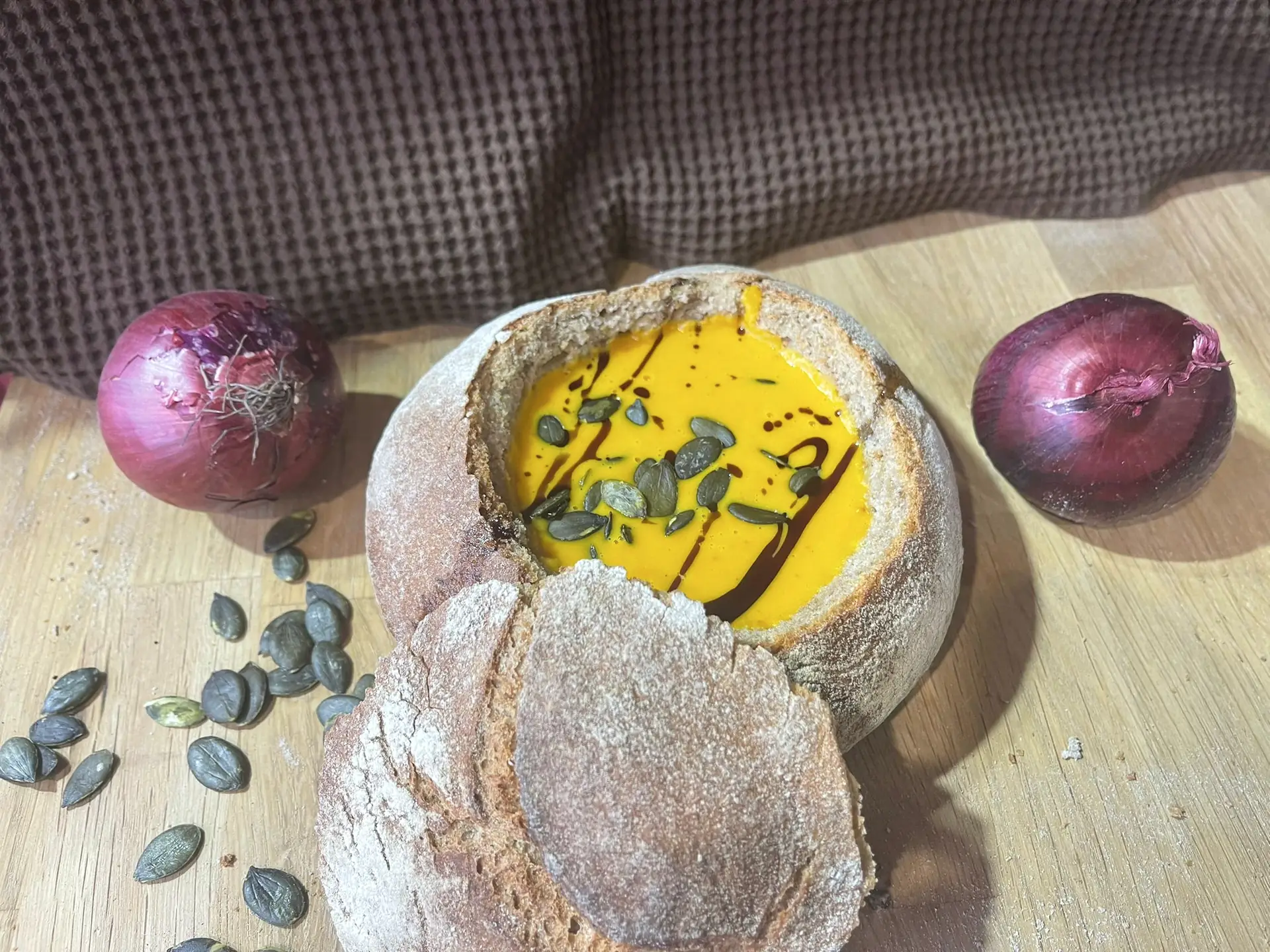 Kürbiscremesuppe im Brotlaib mit Kürbiskernen und einem Faden Kernöl