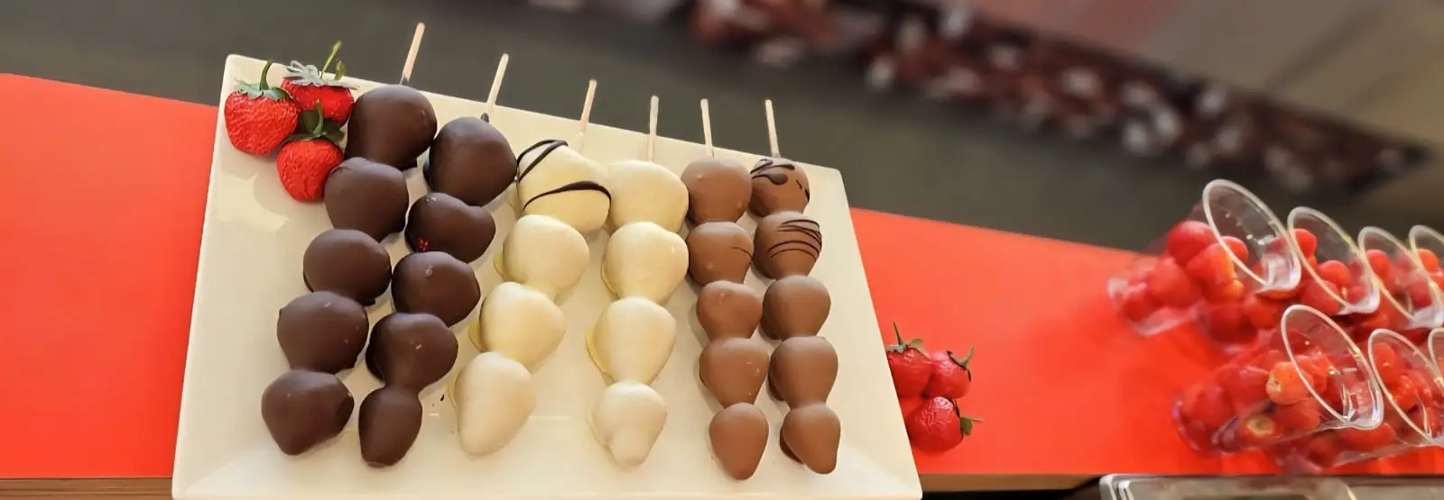 Erdbeeren und Trüffel in weißer, heller und dunkler Schokolade nebeneinander