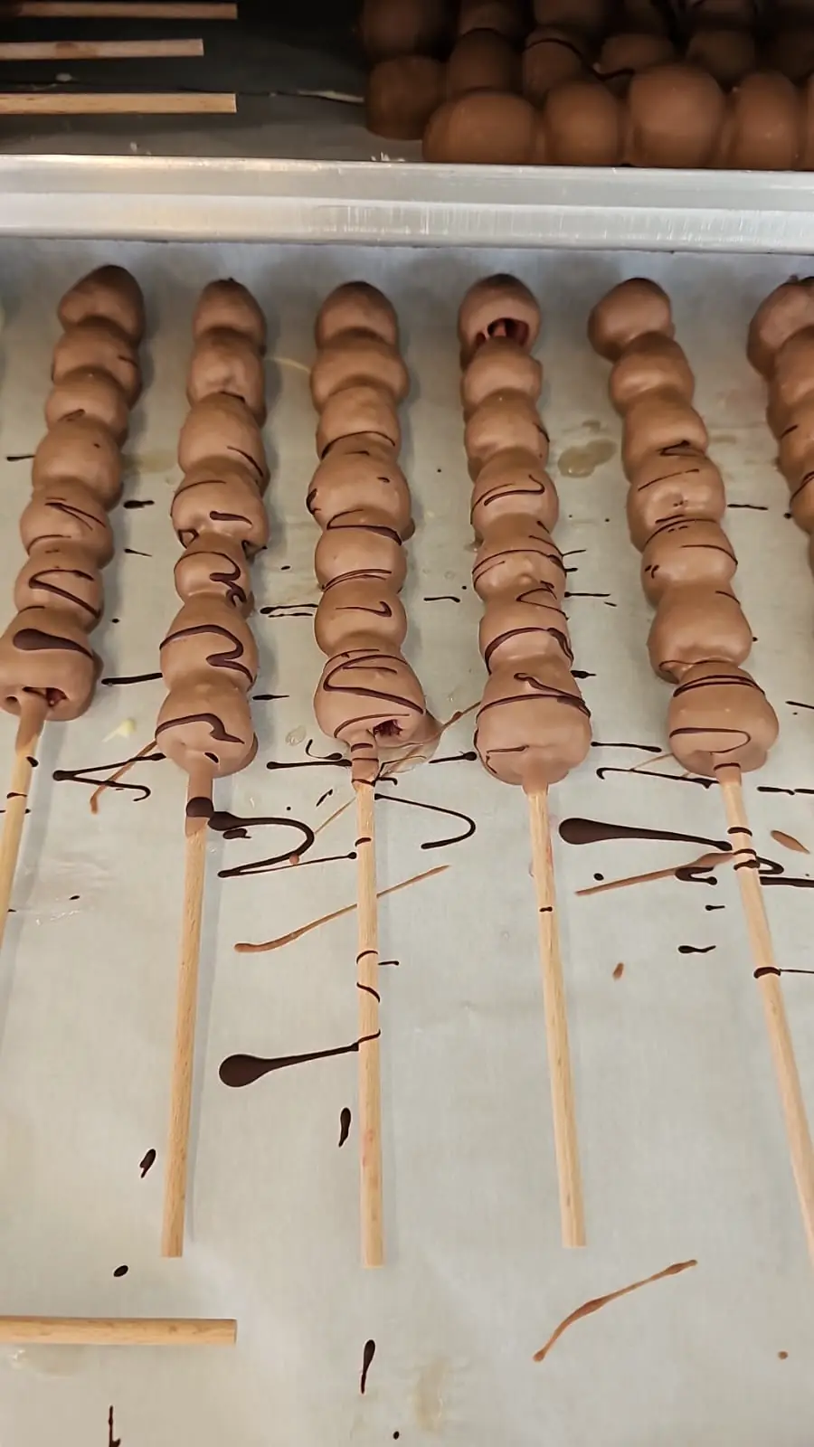 Schokofrüchte am Spieß in Reihen, weiße und dunkle Schokolade